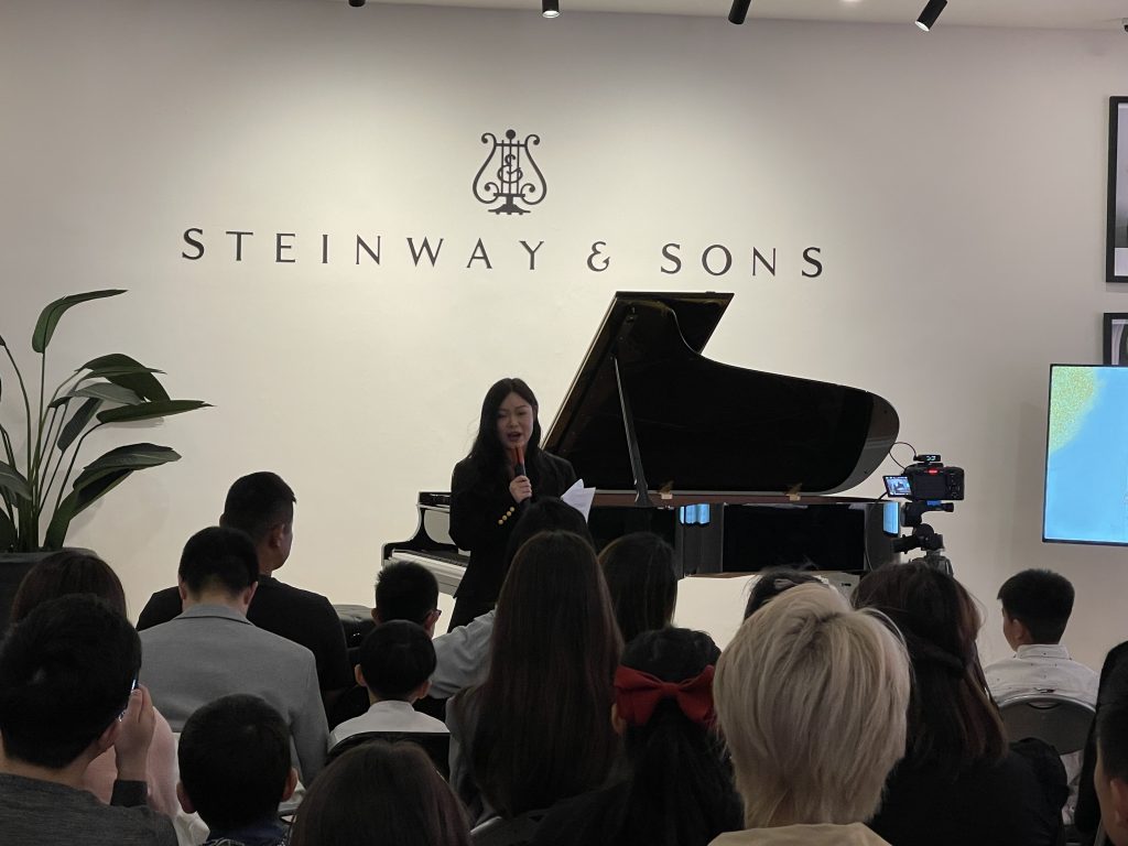 Jeanette Zhang addressing the audience at the start of her students' recital at Steinway Gallery Melbourne